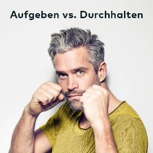 Ein Mann im gelben T-Shirt hat die Fäuste in Boxer-Ausgangslage erhoben. Über seinem Kopf steht: 'Aufgeben vs. Durchhalten'.