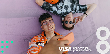 Zwei junge Männer liegen entspannt auf dem Boden. Auf dem Bild ist das Logo von Visa mit dem Zusatz „Everywhere you want to be“ platziert.