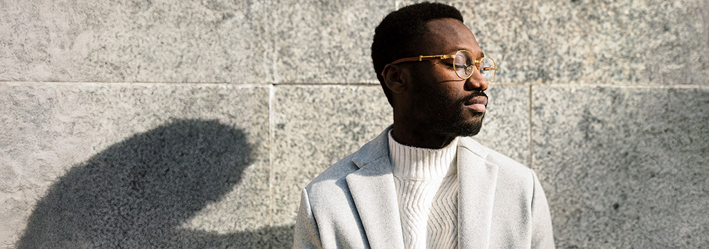 Frau lehnt ruhig an Betonwand und schaut entschlossen