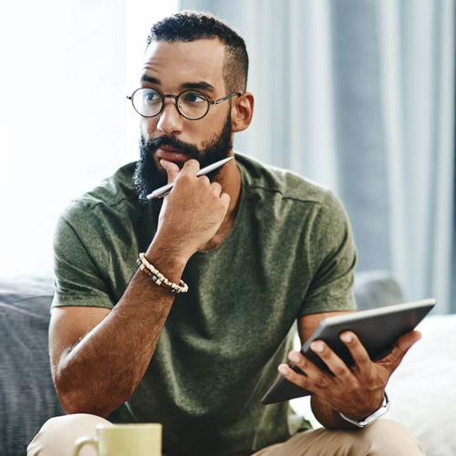 Ein junger Mann nimmt über sein Tablet an einer comdirect online Veranstaltung teil.