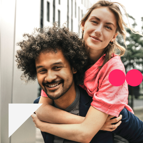 Ein junger Mann trägt eine junge Frau Huckepack. Beide lächeln. Sie haben eine Geldanlage, die zu ihnen passt. 